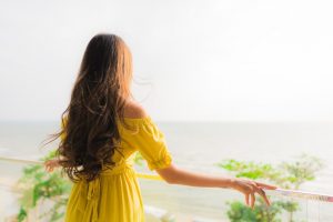 portrait-beautiful-young-asian-woman-smile-happy-relax-outdoor-balcony-with-sea-beach-oce_74190-8290